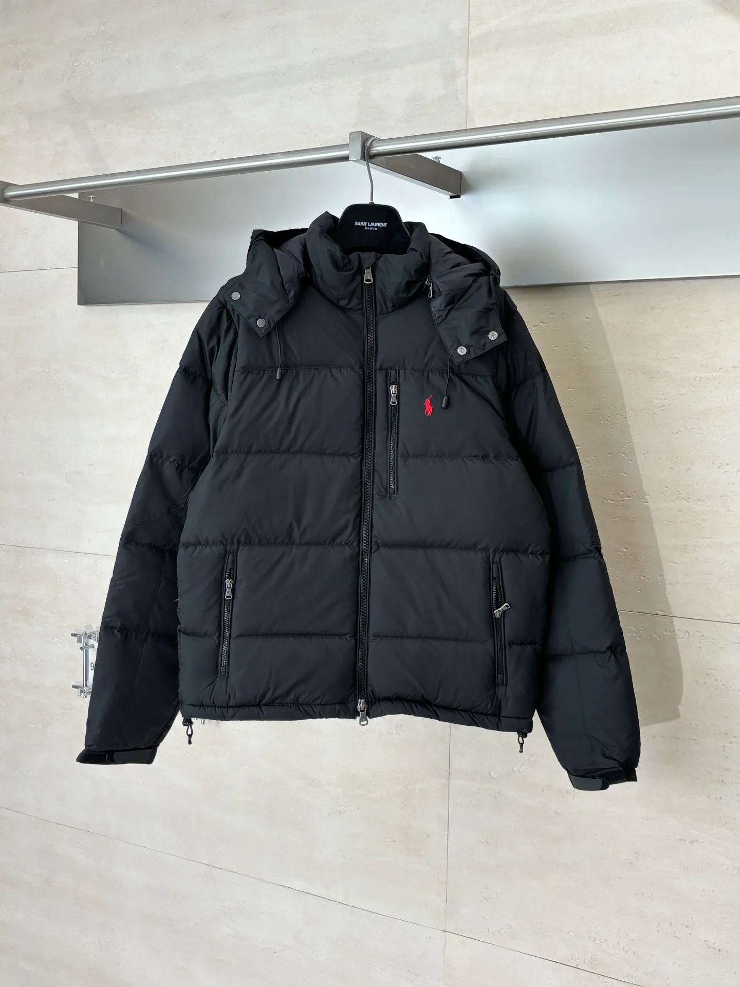 P970 Rah Laure*/Ralph Lauren solid color classic red label pony embroidered hooded down jacket. The nylon fabric has good windproof and waterproof properties, which can effectively block the intrusion of wind and rain from the outside and keep the interior dry. It is suitable for wearing in humid or rainy environments. The chest label uses an imported MEO embroidery machine. It first scans the original pattern and then uses high-quality silk thread to make a pattern. The density effect is adjusted by continuous pattern making. Detachable: Equipped with detachable nylon, users can easily disassemble or install it according to weather changes or personal preferences, which is both practical and convenient. Exquisite details: the zipper design is simple and elegant, easy to operate; the closing design of the cuffs and hem effectively prevents the intrusion of cold wind, improving the warmth and comfort of wearing. It uses 90 white duck down with a weight of 260g to ensure excellent thermal insulation performance. After strict screening and processing, the velvet is not easy to get drilled, ensuring durability. The overall wiring is straight and delicate, the fabric is comfortable and soft, and the color is consistent without color difference. It can be matched with the same style to create a fashionable look and control various occasions. Customized accessories, complete with three standards, same style for men and women!  Size: S/M/L/XL/XXL